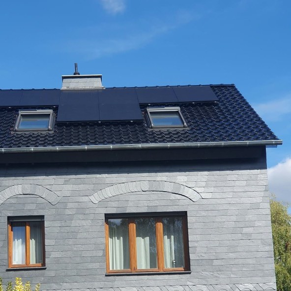 Gedecktes Dach mit zwei Dachfenstern über einer grauen Fassadenbekleidung.